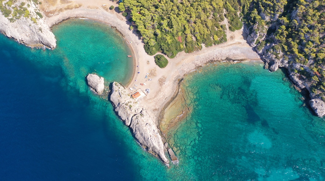 Aerial drone top down photo of scenic half moon shaped crystal clear sea beach of Milokopi near famous lake Vouiagmeni, Loutraki, Perachora, Greece