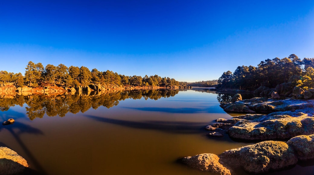 panoramic of lake at morning with blue sky and forest around in arareco lake, creel chihuahua