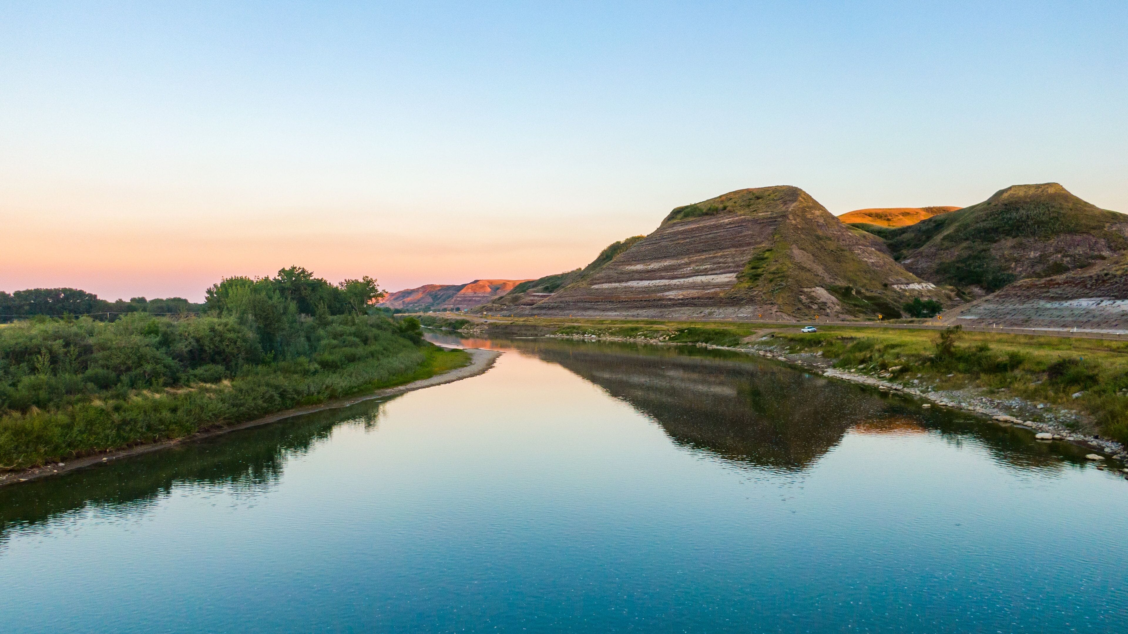 Drumheller featuring a river or creek, a sunset and mountains