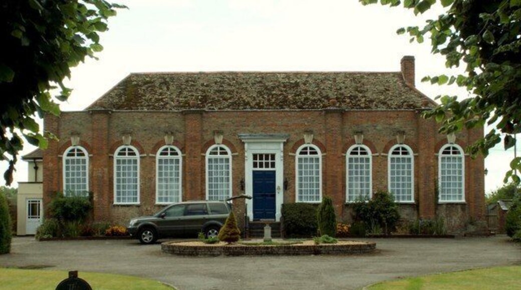 The School House in Chippenham This school stands opposite the church tower and was built of red brick in 1714. It is one-storeyed, of nine bays with arched windows, pilasters grouping the windows, vases on the pilasters and a straight-headed doorway.