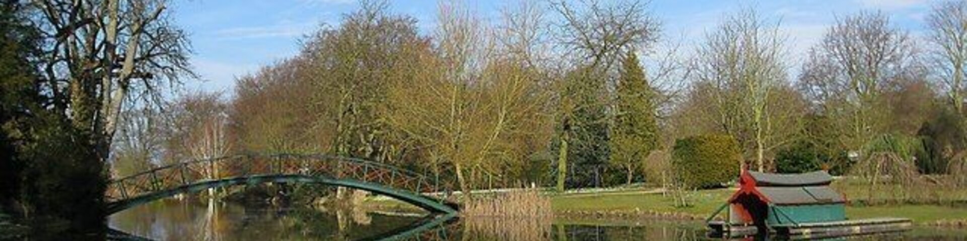 Reflecting Bridge The still waters of the man made lake reflect both the bridge and the boat hut.