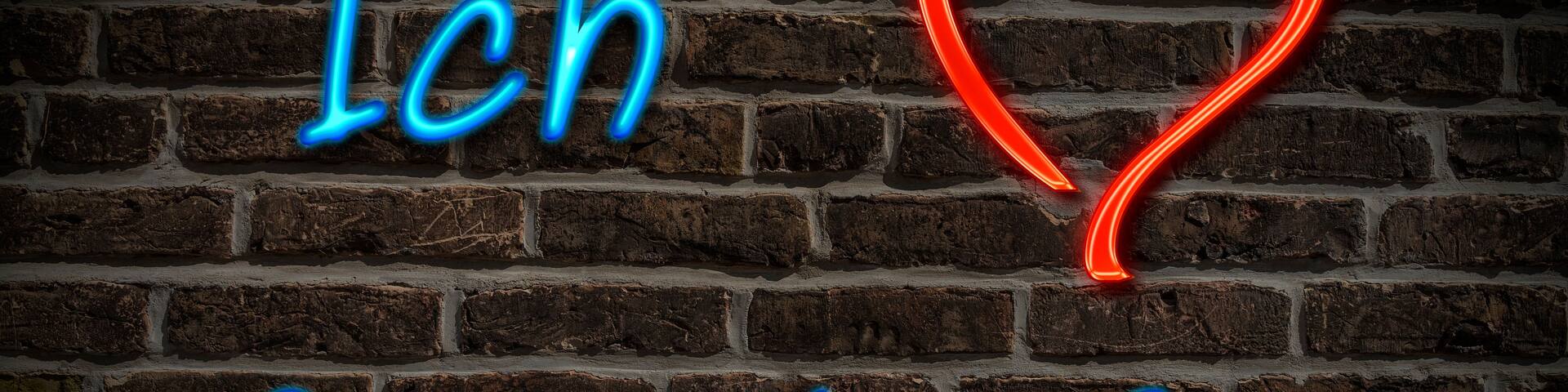 A brick wall with neon signs spelling 'Ich Gersthoffen' and a red heart.