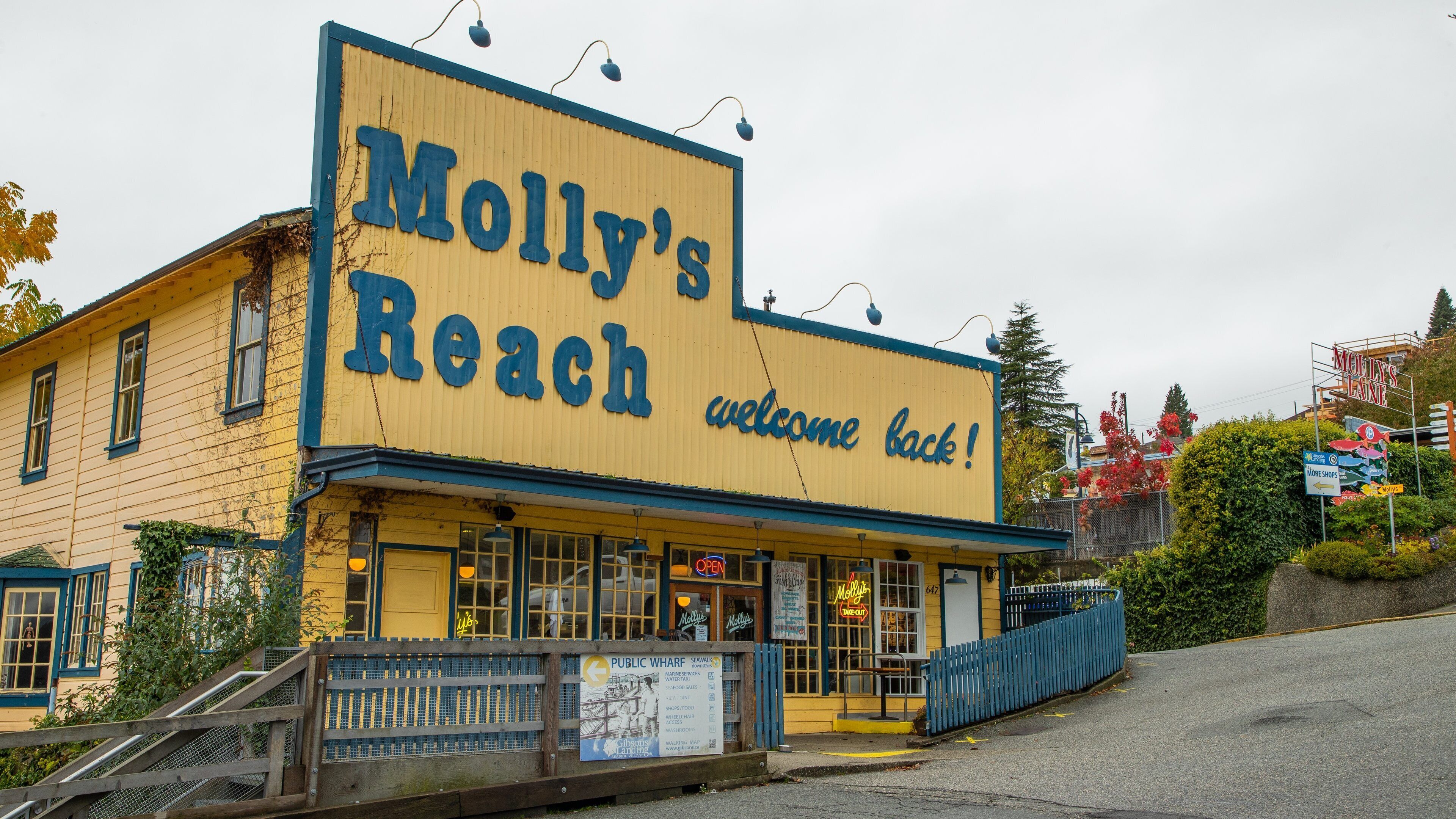 A yellow building with a large sign reading "Molly's Reach welcome back!"
