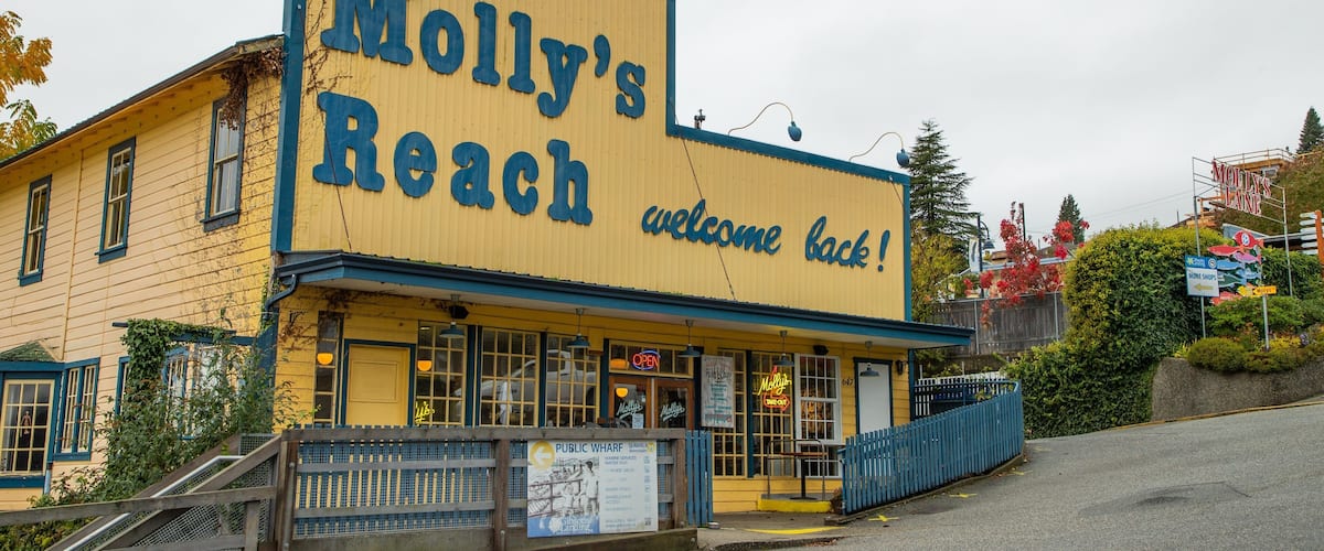 A yellow building with a large sign reading "Molly's Reach welcome back!"