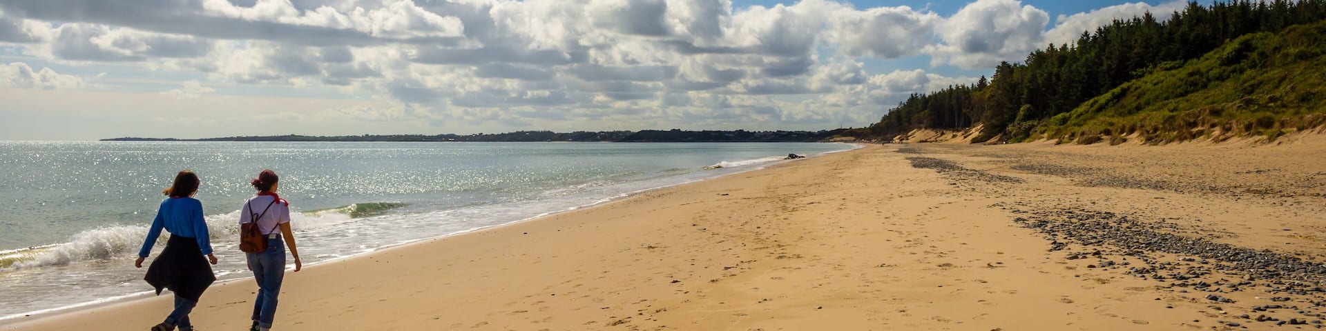 Two people walking down Kiltennel Beach, County Waterfor, Ireland.