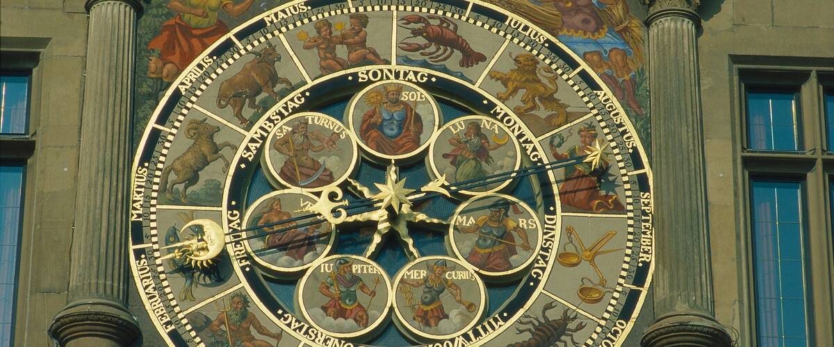 A large, ornate astronomical clock with zodiac symbols and Roman numerals.