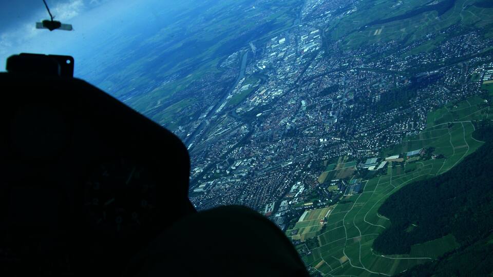 A cityscape with a mix of urban and rural areas, including fields and residential zones.