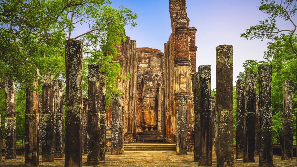 Ancient ruins with tall stone columns and a central structure.