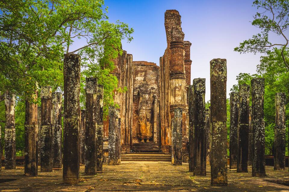 Ancient ruins with tall stone columns and a central structure.