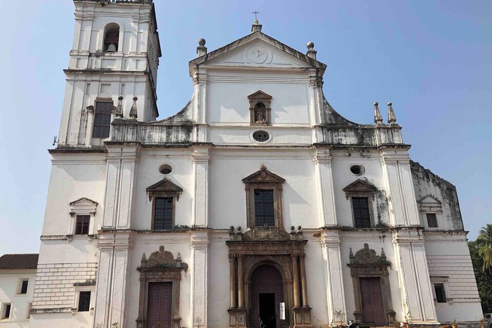 A large white church with a bell tower and a clock.