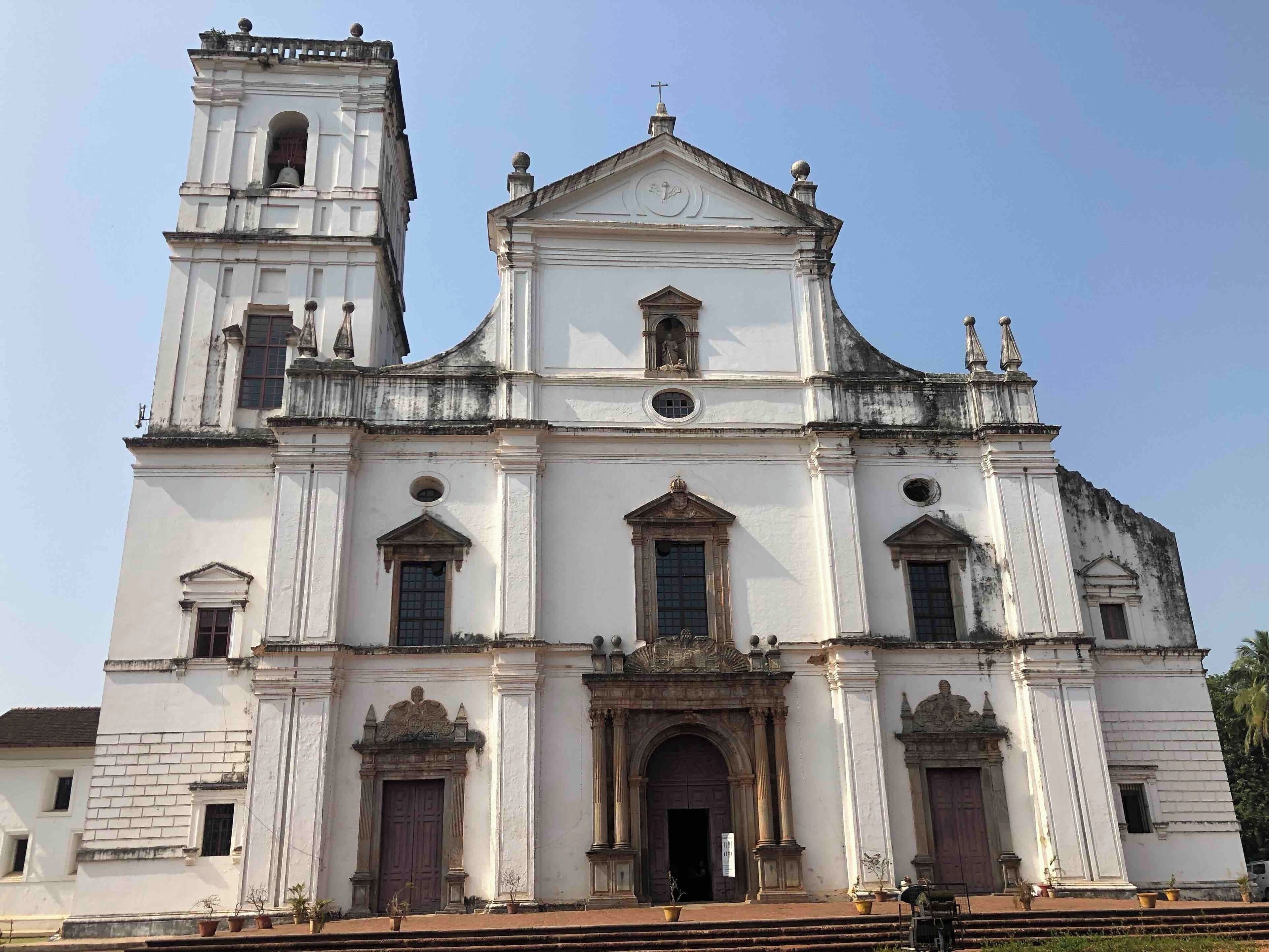 A large white church with a bell tower and a clock.