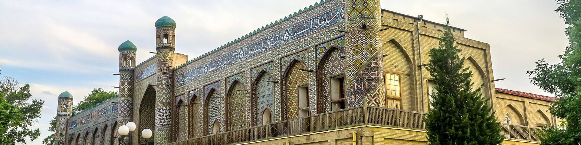 Un edificio histórico con detalles intrincados en azulejos y dos alminares.
