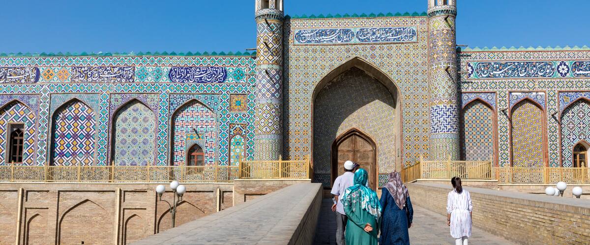 A historic building with intricate tile work and two minarets.
