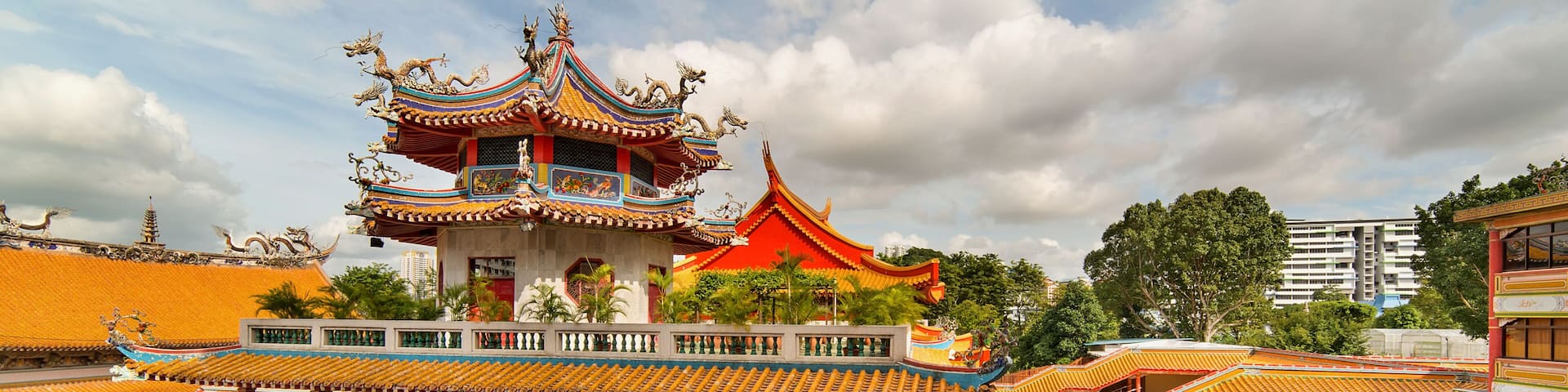 A traditional multi-tiered temple with ornate roofs and a lush garden.