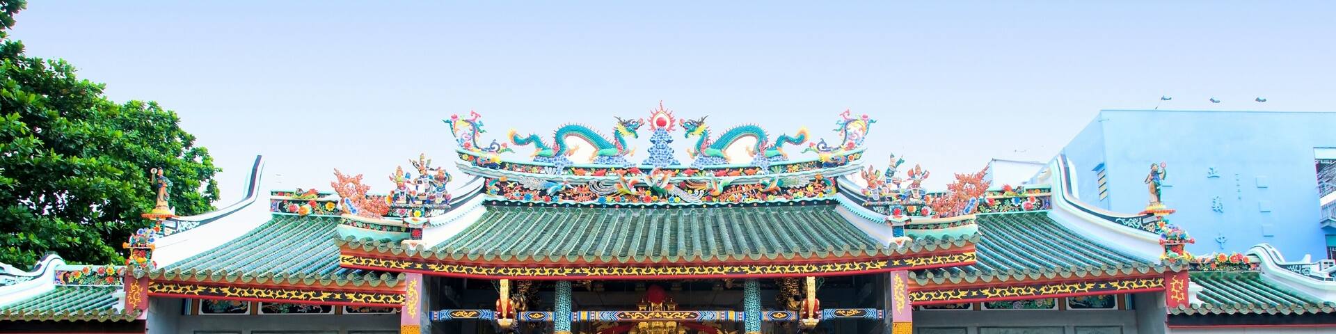 A traditional Chinese temple with ornate architecture, including a multi-tiered roof and statues of lions.