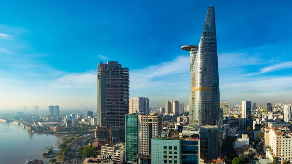 A cityscape with two prominent skyscrapers, a river, and a dense urban environment.