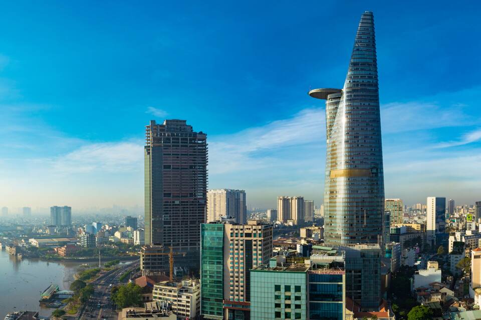 A cityscape with two prominent skyscrapers, a river, and a dense urban environment.