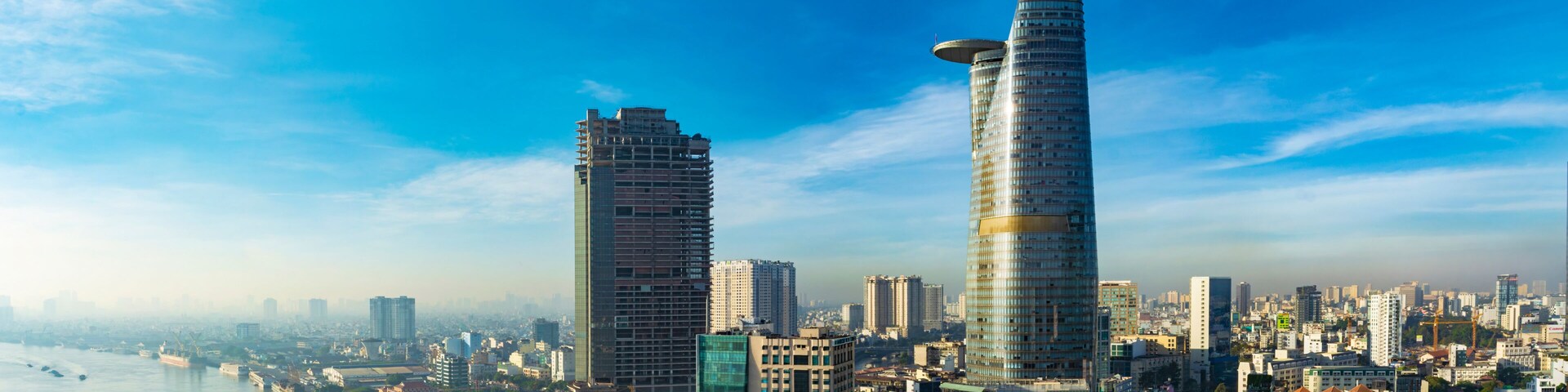 A cityscape with two prominent skyscrapers, a river, and a dense urban environment.
