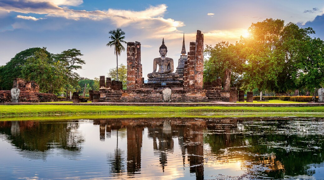Buddha statue and Wat Mahathat Temple in the precinct of Sukhothai Historical Park, Wat Mahathat Temple is UNESCO World Heritage Site, Thailand.