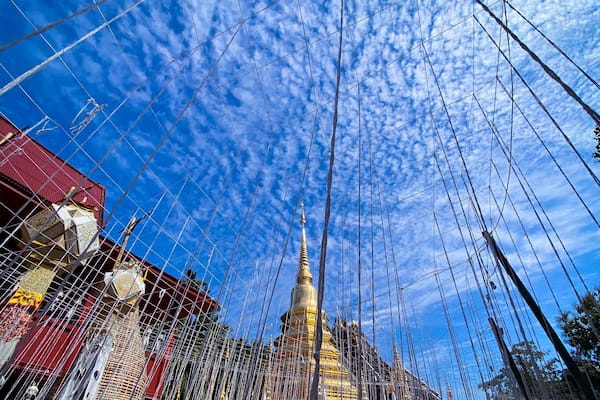 Un temple surmonté d’une flèche dorée, entouré d’une clôture en fil de fer.