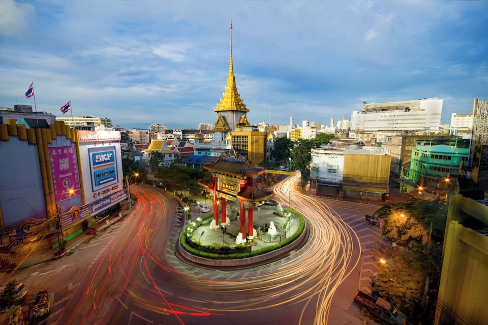 A cityscape with a prominent golden spire, a roundabout with traffic lights, and various commercial buildings.