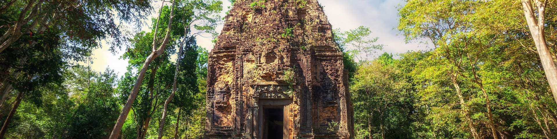 E8EBNR Ancient Khmer pre Angkor architecture. Sambor Prei Kuk temple ruins with giant banyan trees under blue sky. Kampong Thom, Cambod