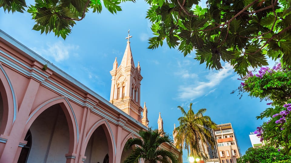 Da Nang Cathedral and beautiful tropical vegetation against the blue sky. This is one of the main architectural tourist attractions of Da Nang City.