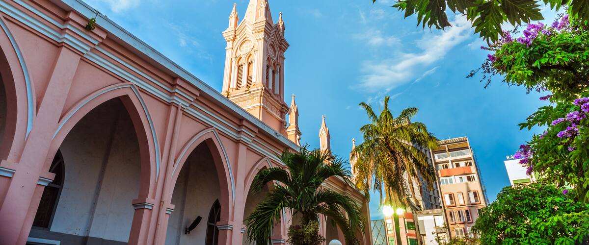 Da Nang Cathedral and beautiful tropical vegetation against the blue sky. This is one of the main architectural tourist attractions of Da Nang City.