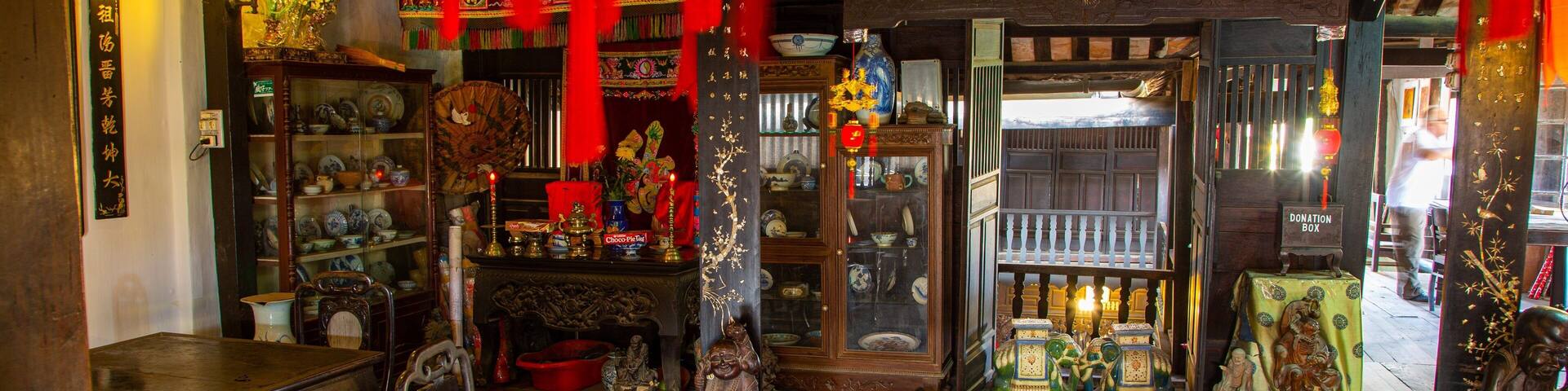A traditional Chinese shop interior with wooden furniture, red decorations, and various items on display.