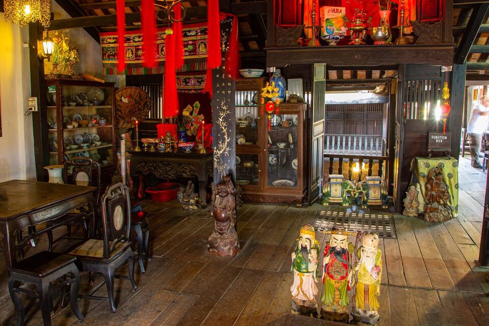 A traditional Chinese shop interior with wooden furniture, red decorations, and various items on display.
