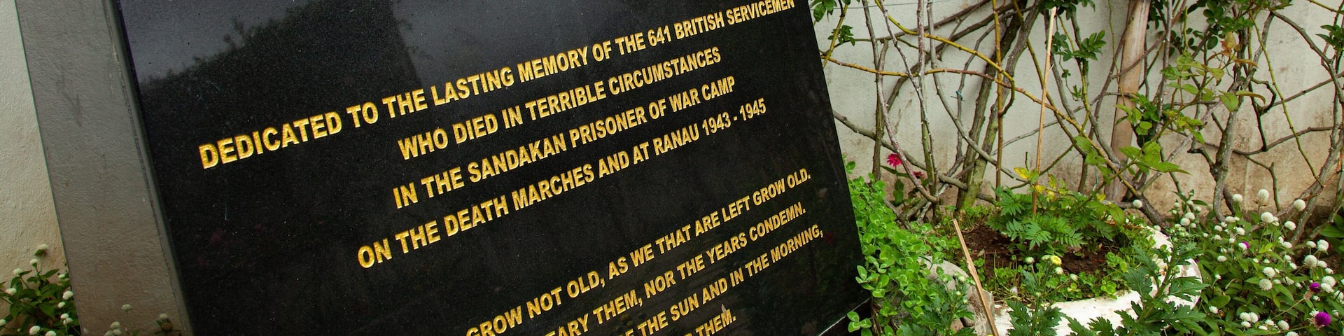 Una placa conmemorativa con una bandera británica y texto dedicado a los 641 militares británicos que murieron en el Campo de Prisioneros de Guerra de Sandakan y en Ranau, 1943-1945.