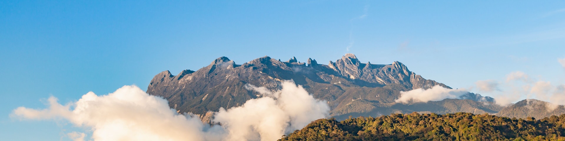 view of Mount Kinabalu emerges out from the clouds at near sunsets