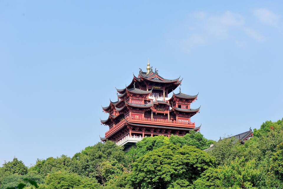 A multi-tiered pagoda with intricate architecture, surrounded by lush greenery.