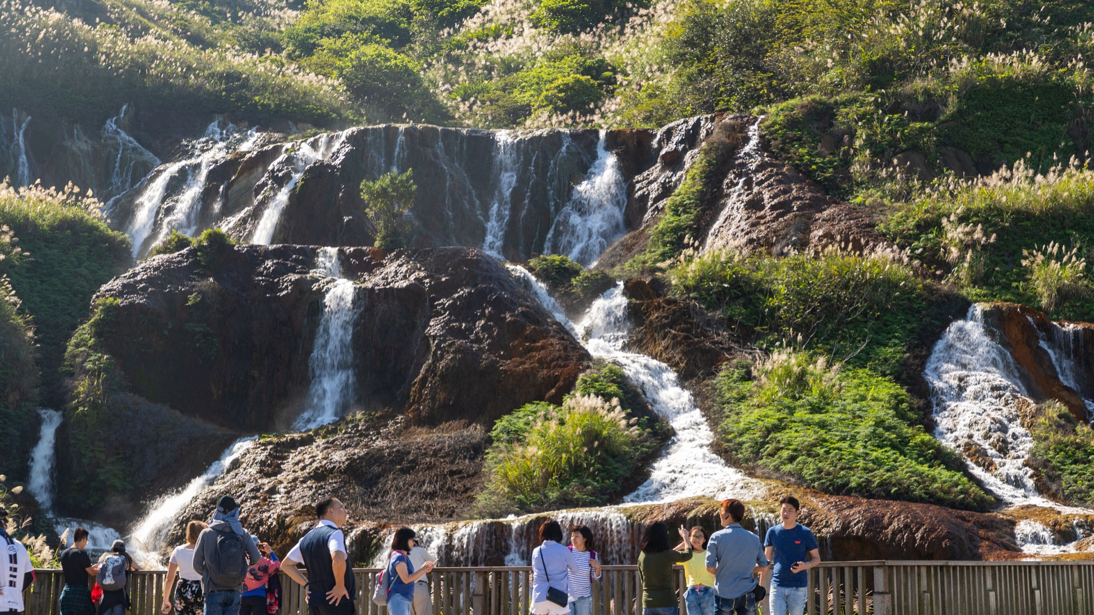 Golden Waterfall showing a waterfall and a river or creek as well as a small group of people