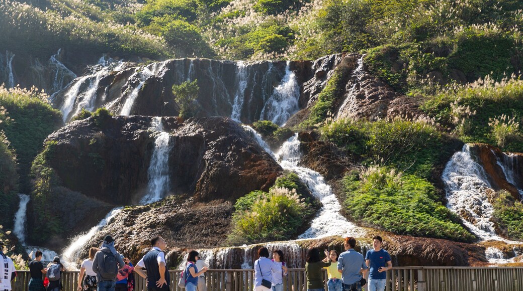 Golden Waterfall showing a waterfall and a river or creek as well as a small group of people