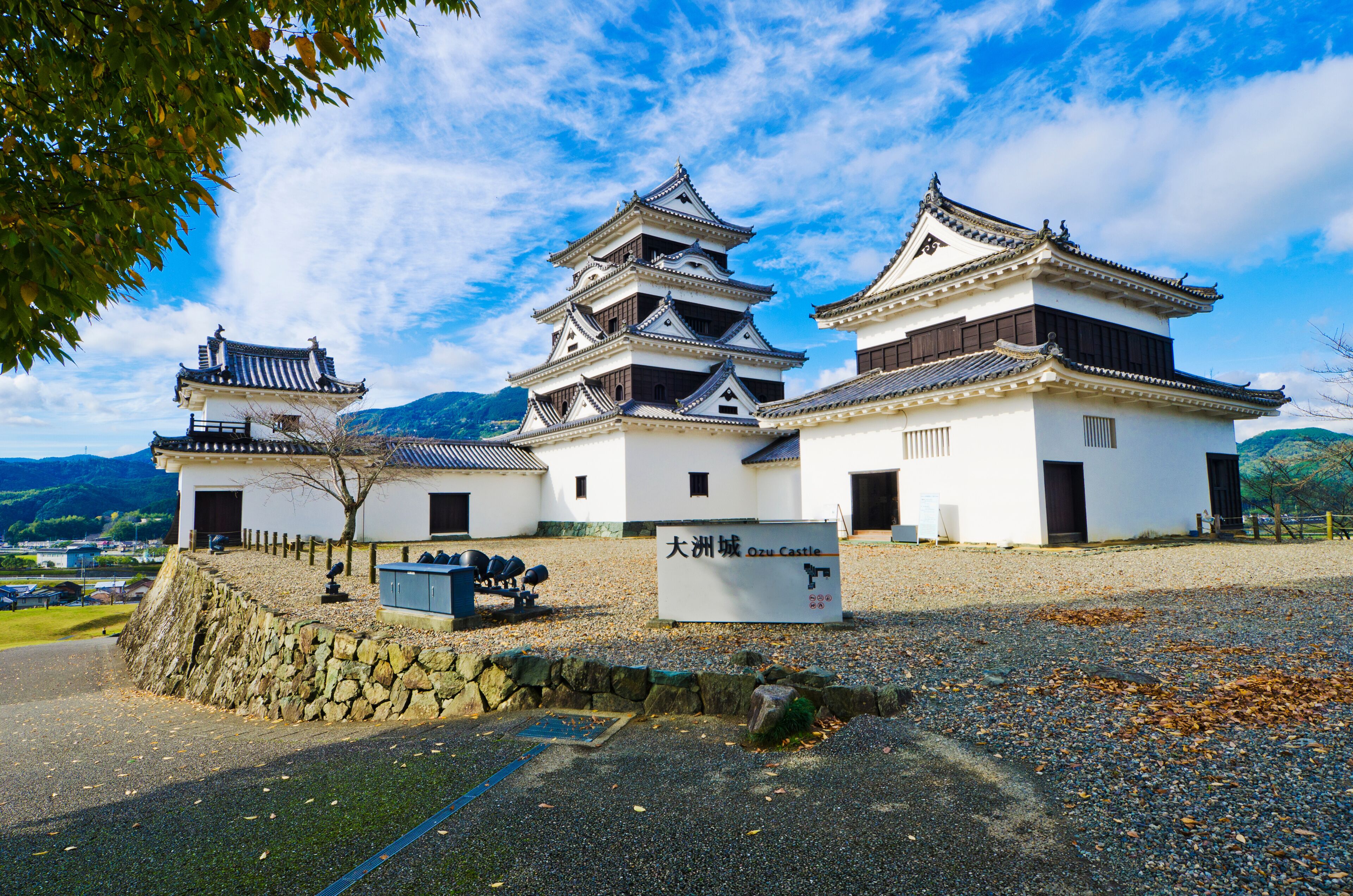 A traditional Japanese castle with multiple towers and a stone wall.