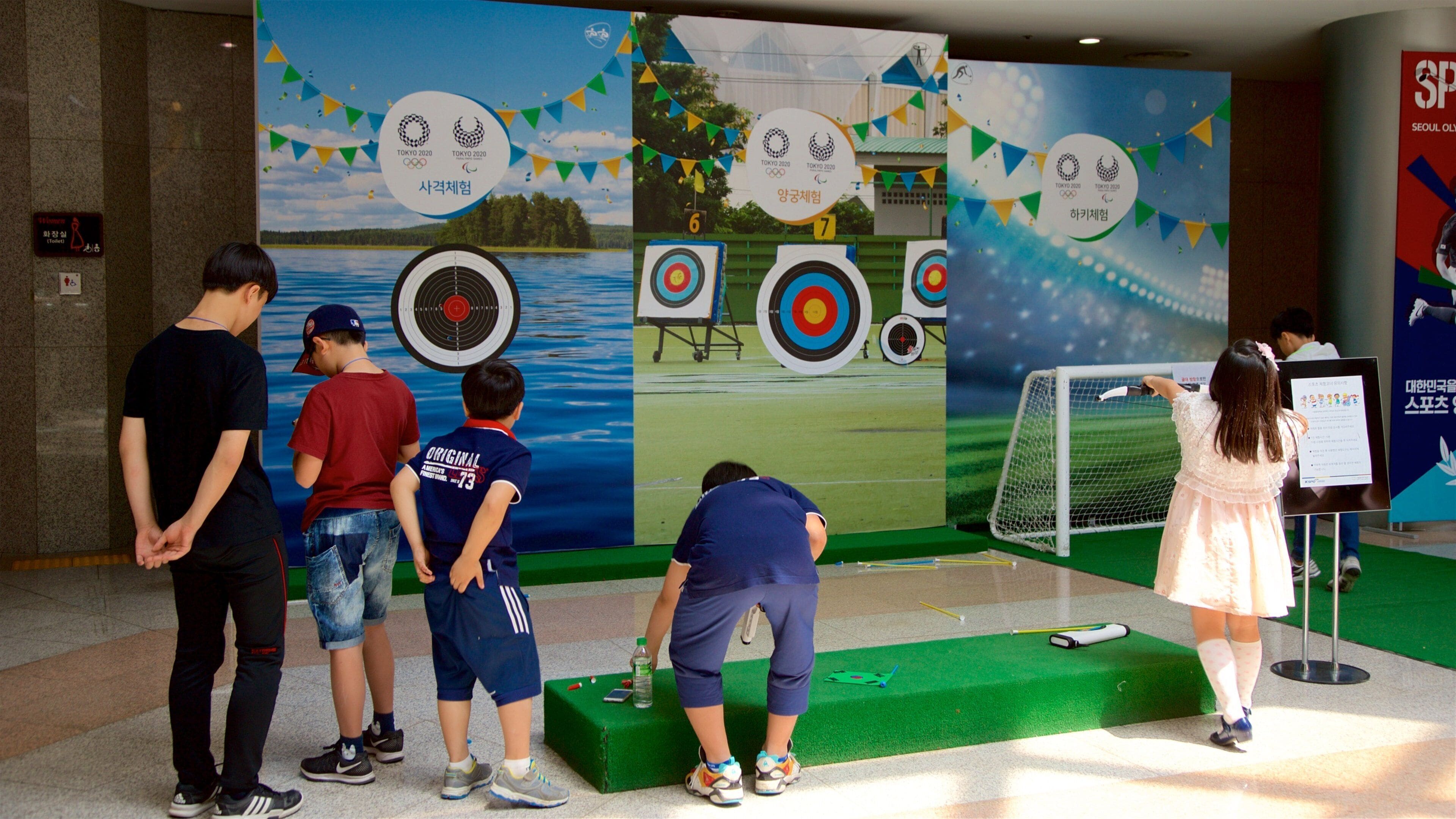 Seoul Olympic Museum featuring interior views and signage as well as a small group of people