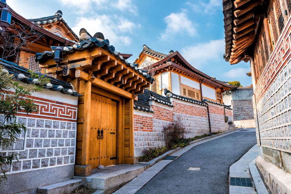 A traditional Korean building with a wooden door and tiled roof.