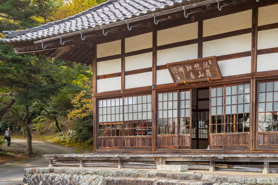 A traditional Japanese building with a tiled roof and wooden lattice windows.