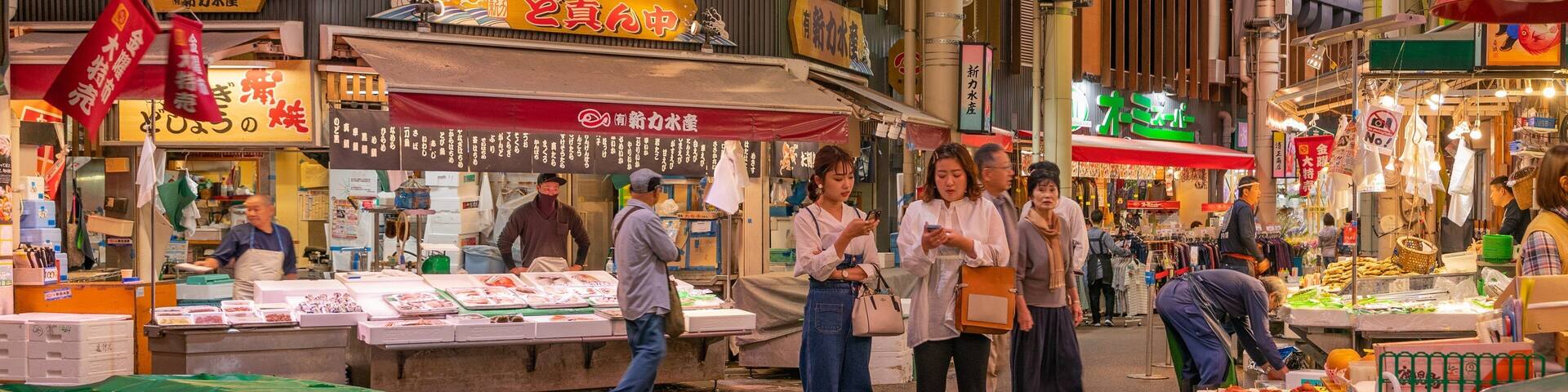 Un mercado interior animado con diversos puestos que venden mariscos y otros productos.