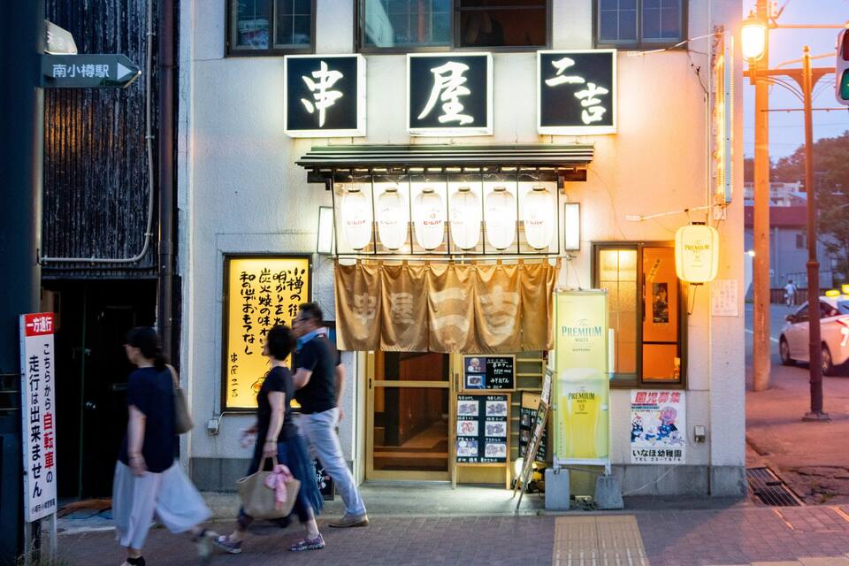 A storefront with Japanese signage and a display of sake bottles.
