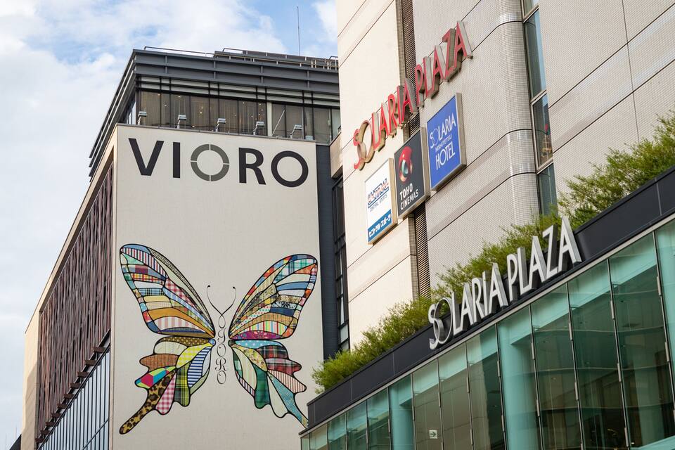 En bygning med et farverigt butterfly-maleri og skilte med 'VIORO' og 'SOLARIA PLAZA'.