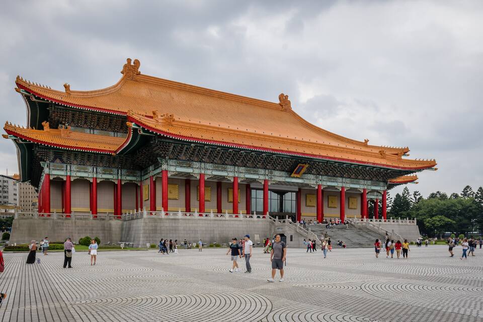 A traditional Chinese building with a curved roof and red pillars.