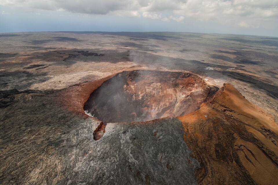 A vast volcanic crater surrounded by rugged terrain.