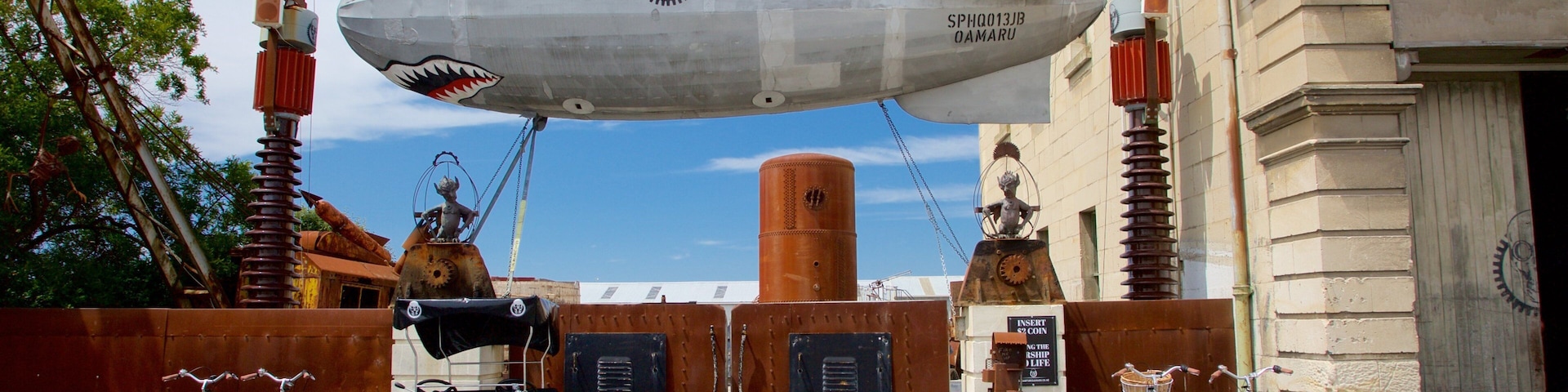 Un gran dirigible estacionado frente a un edificio con un letrero que dice "INSERT 2 COINS".