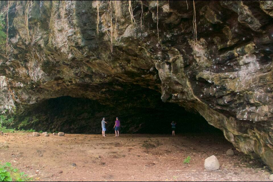 A cave entrance with rocky walls and a dirt path leading into it.