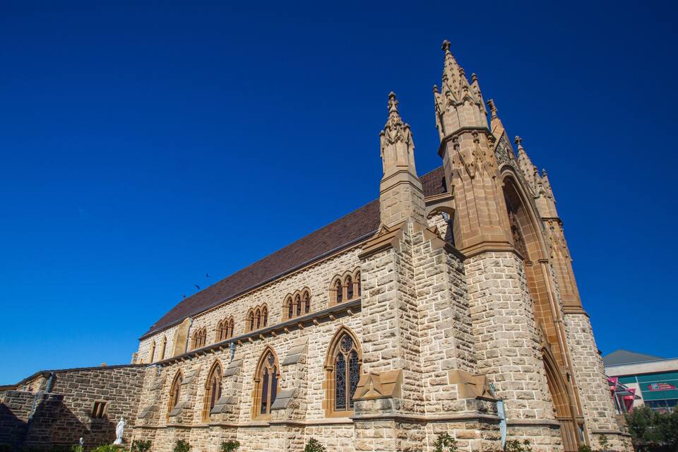 A large stone church with two tall spires and arched windows.