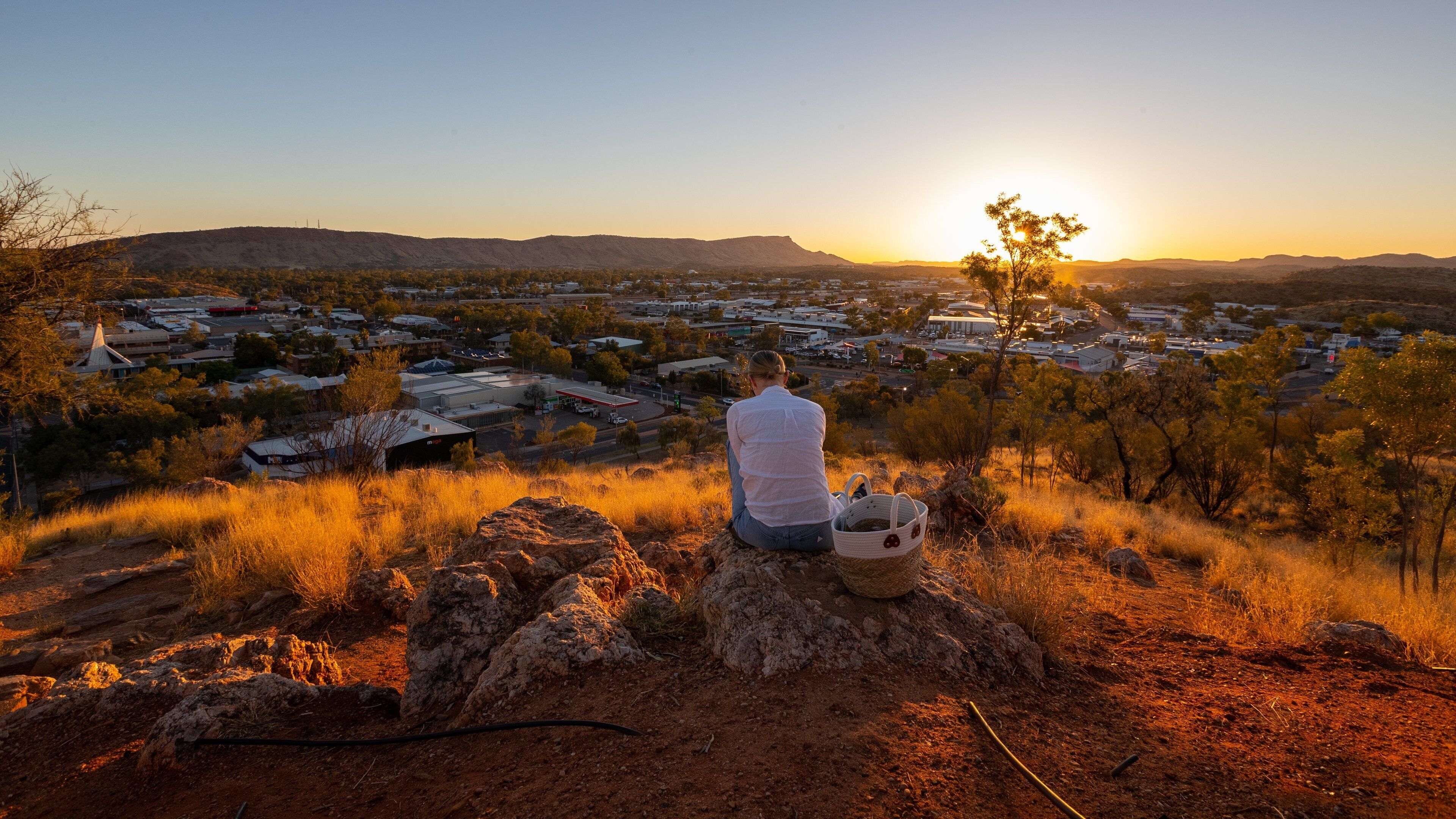 Anzac Hill showing a sunset, desert views and a small town or village