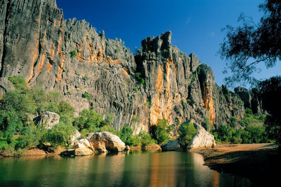 A river with rocky cliffs and dense greenery.