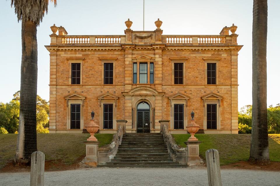 A large, historic building with a symmetrical facade, large windows, and a central entrance.